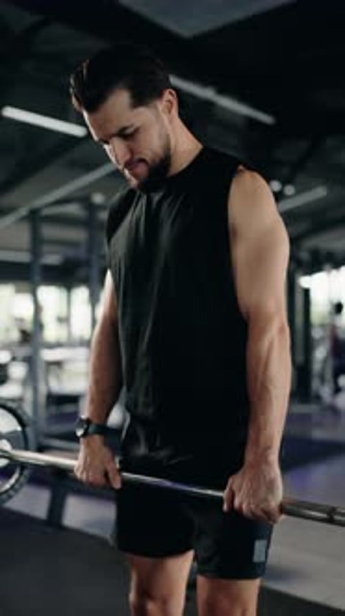 Muscular Athlete Man Doing Front Squats Exercise with a Barbell in the Gym