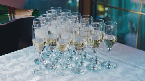 Closeup Champagne is Pouring Into a Glass A Waiter Pours Champagne Wine Into Glasses at a Buffet