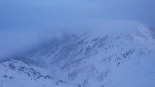 Snowy Mountains and Misty Clouds Aerial View