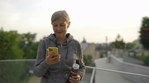 Active Senior Woman Using Phone after Workout