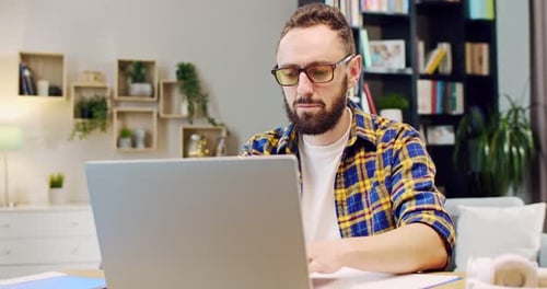 Adult Man Works on Laptop at Home