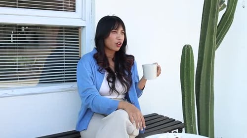 Cheerful Asian Woman Talking While Enjoying Eating Cake And Drinks Coffee At Cafe