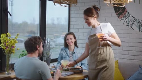 A Friendly Waitress in a Cozy Cafe Brought Drinks to a Pleasant Couple