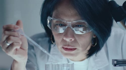 Scientist Using Pipette in Brightly Lit Laboratory