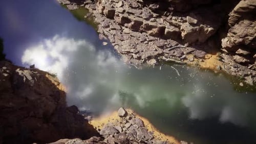 Tranquil Gorge Mirrored By Tranquil Water and Rocky Textures