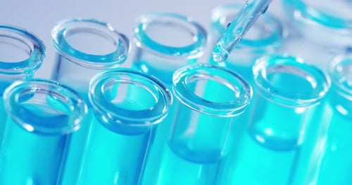 Dropping Blue Liquid into Glass Test Tubes
