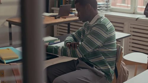 Étudiant afro-américain étudiant et prenant des notes en classe