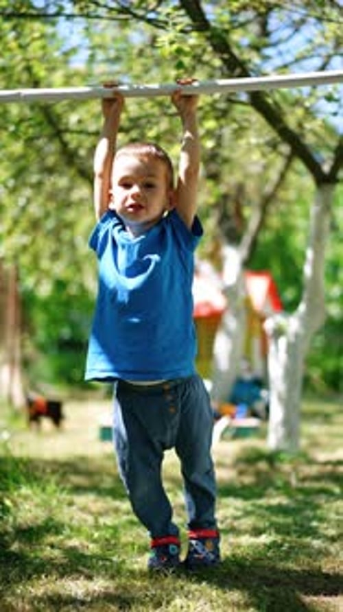 Lovely child appears from the tunnel slide. Smiling kid stands on his feet and runs to slide again.