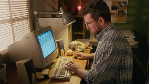 Mann arbeitet zu Hause am Finanzbericht auf einem Vintage-Desktop-Computer