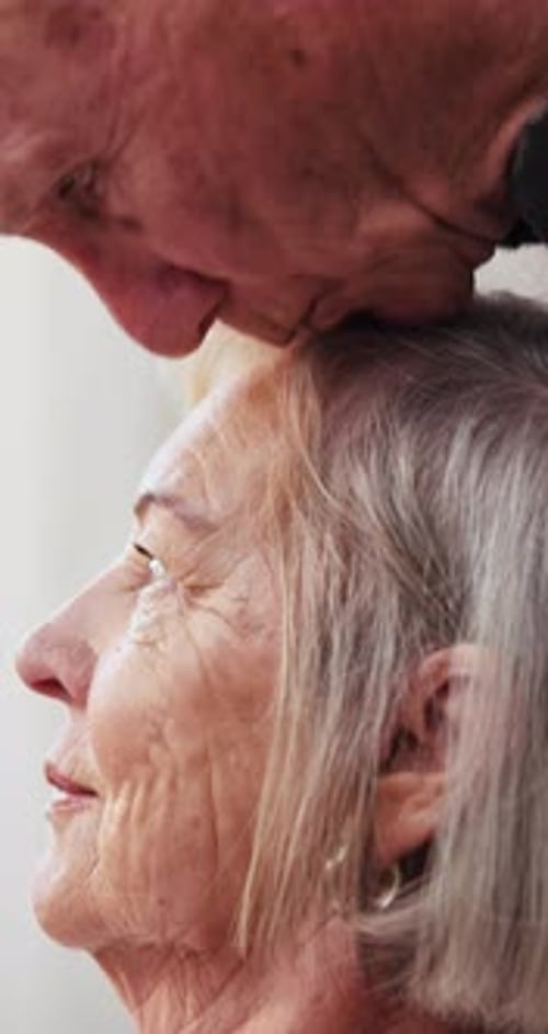 Elderly Couple Expressing Love With Forehead Kiss