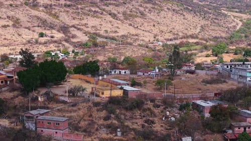 Rustic Mountain Village Nestled Among Arid Slopes and Green Trees