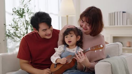 Young Family Sings and Plays Ukulele in Living Room