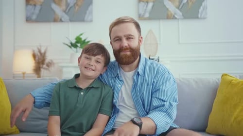 Father and Son Smiling Together on the Couch