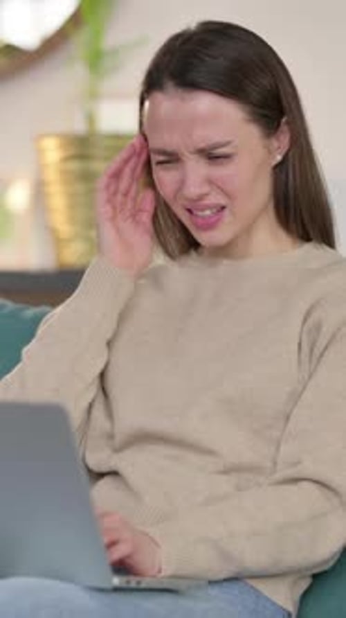 Woman Using Laptop Massaging Temples Suffering from Headache