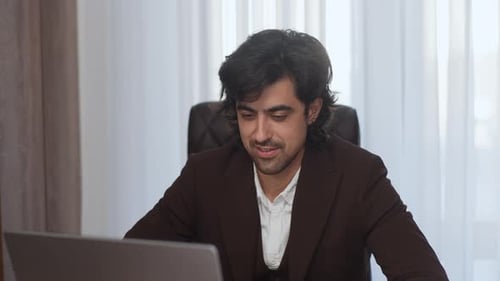 Man Works at Laptop in Office Environment