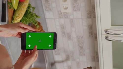 Vertical Screen Women at phone with green screen watching online video