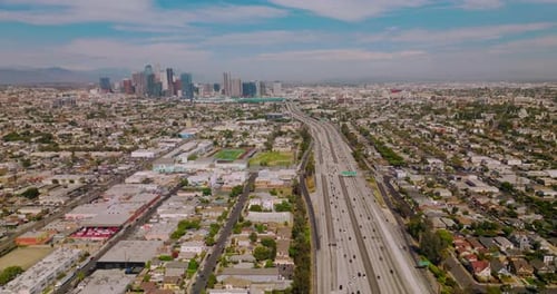 Wide busy road with numerous cars moving to and from financial downtown.