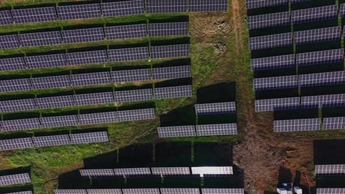 Solar panels arranged in rows at a solar energy farm on a sunny day