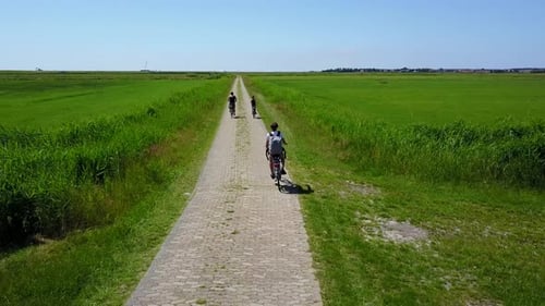 teenage boy, girl, and mother cycling in the countryside in the Netherlands. Three people riding a b