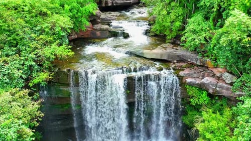 A stunning waterfall cascading through nature's beauty. Drone view.