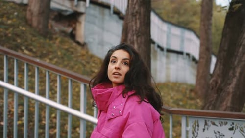 Attractive Young Female Walking in Autumn Park While Going Up the Stairs Lady Wearing Pink Jacket