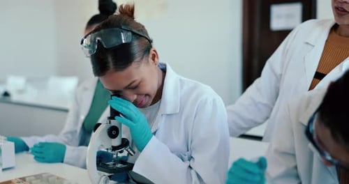 Enthusiastic Students Working With Microscopes in Bright Lab
