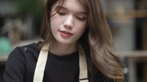 Young women is making earthenware at workshop.