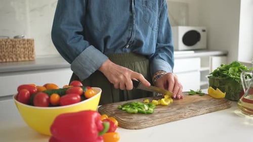 Woman Slicing Yellow And Green Pepper