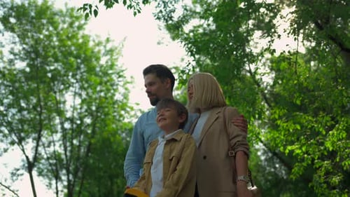 Happy Family with Child Enjoying a Sunny Day Together in a Green Park Clip