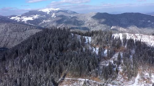 Aerial view of snow covered mountain forest at winter