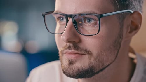 Focused Man Working at Computer With Glasses