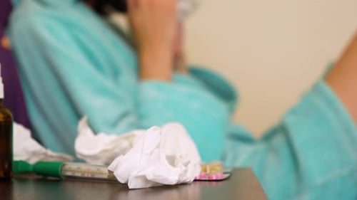 Une femme dépose un mouchoir après un écoulement nasal. Un rhume