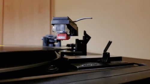 Hand Places Needle on Black Record Player