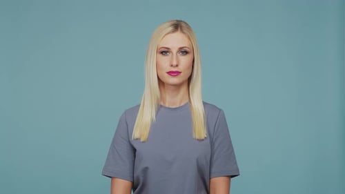 Young Beautiful Blond Girl in the Studio Portrait of Emotional Girl on Blue Background