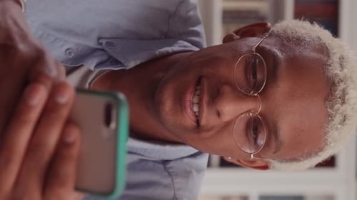 Young Adult Smiling at Phone Indoors