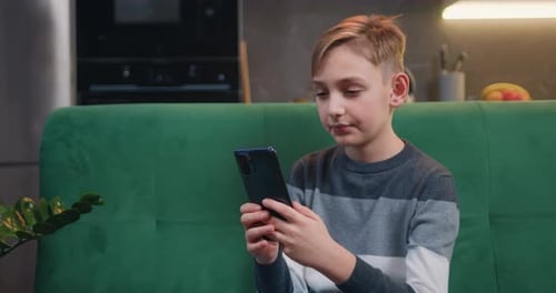 Blonde Haired Child Using Smartphone on Couch