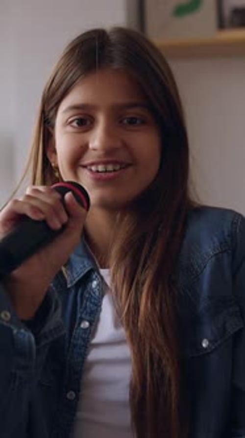 Happy Child Singing into Microphone at Home