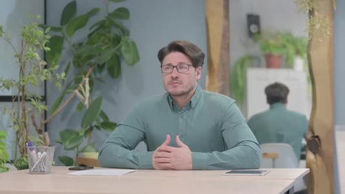 Pensive Middle Aged Man Thinking while Sitting in Office