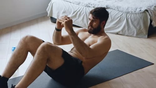 Man Doing Sit-ups on Mat in Bedroom