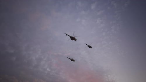 Military Helicopters Flying in Formation Against Evening Sky