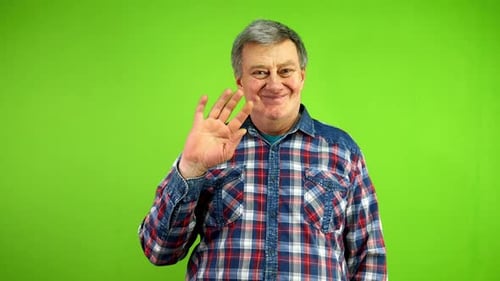 Friendly Senior Man Waves Palm for Greeting or Goodbye Sign