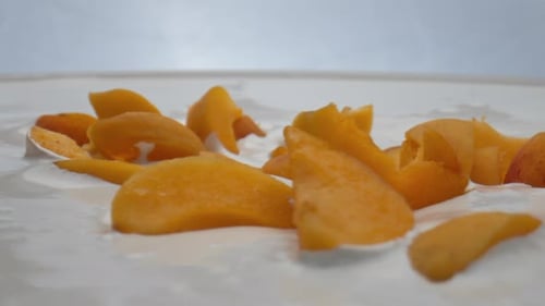 Apricot Dropped Dairy Dessert in Super Slow Motion Close Up