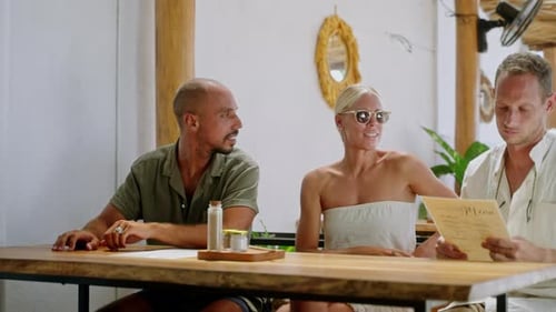 Multiracial Cheerful Friends Looking at Menu Choosing Food in Tropical Cafe Diverse Persons Sitting