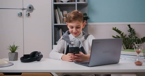 Boy Using Smartphone at Desk Indoors