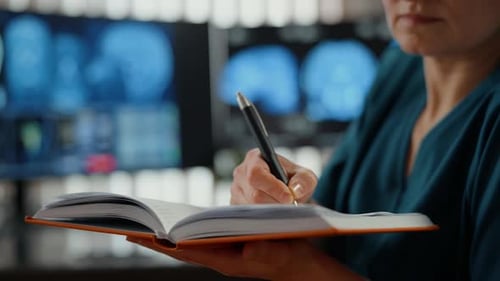 Woman Doctor Writing Notes in Hospital Office