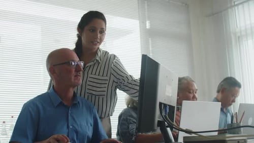 Adults working together on computers in office