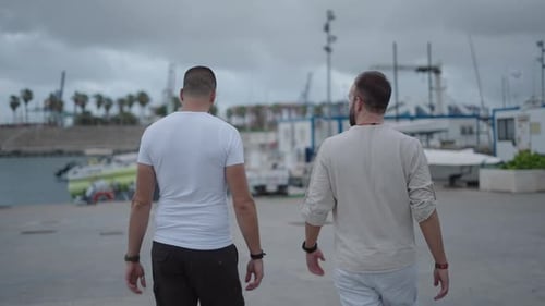 Two Caucasian Men Talking While Walking