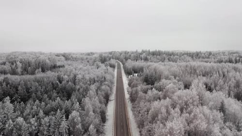 Luftaufnahme einer Autobahn durch Wald auf dem Land. Autos fahren auf einer Straße in der Winterlandschaft w