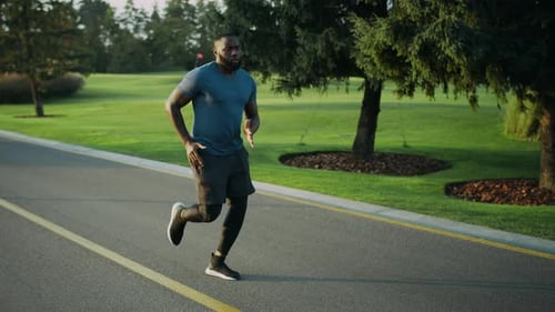 Full Length Active African American Runner Jogging in Park. Male Jogger Training