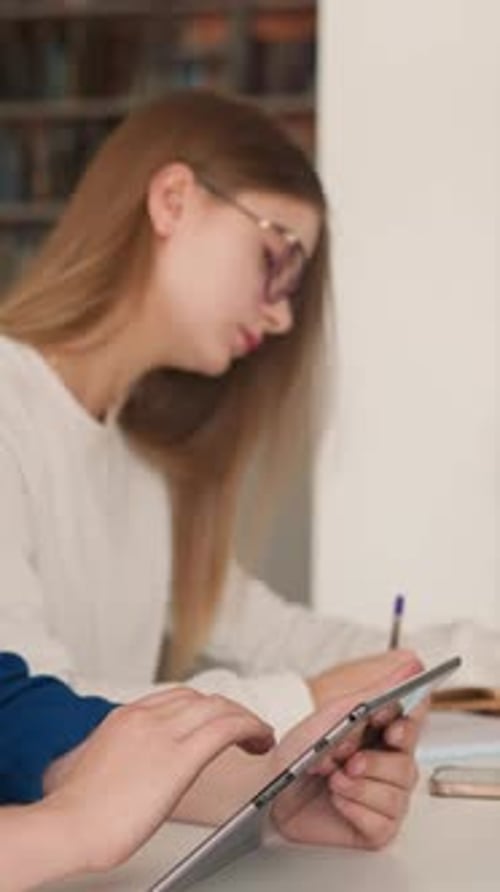 Woman Surfs Internet on Tablet in Library Hall